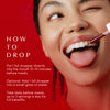 Smiling woman with tongue out while applying Sugar Kick drops. Text explains how to use: 1 full dropper 10–15 minutes before meals, directly or in water, up to 3 servings/day.