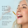 Close-up of golden herbal dropper taken directly on the tongue. Text instructs: take 1 full dropper directly in the mouth or add to a small glass of water, up to 6 servings daily, any time of day for full benefits.